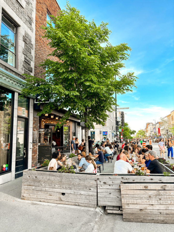 A busy Montreal terrasse on a sunny day. The adjoining street is closed to car traffic.